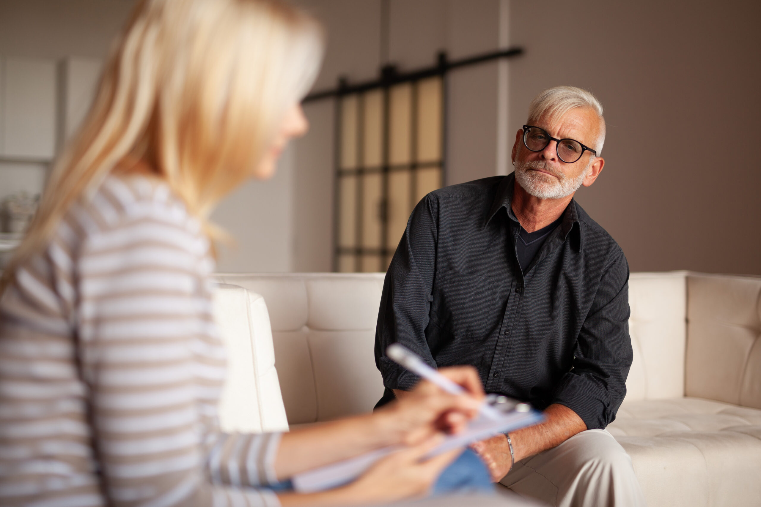 Comfortable psychotherapy. An elderly patient with a problem,  session with a psychologist. The doctor listens and writes down the diagnosis.